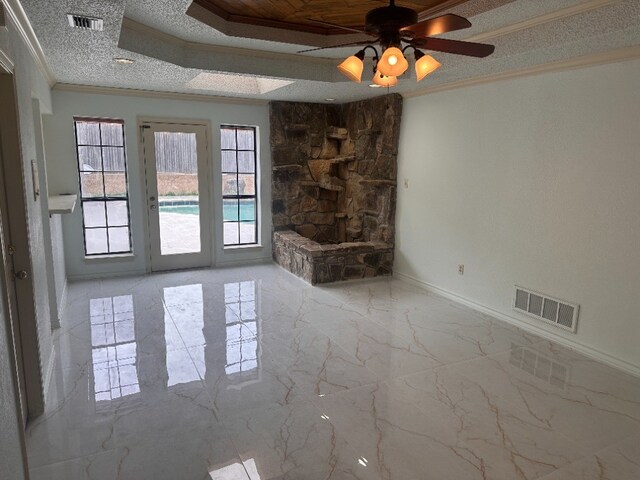 unfurnished living room with crown molding, visible vents, and plenty of natural light