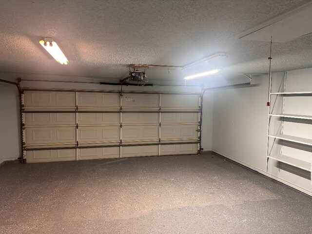garage with baseboards and a garage door opener