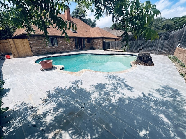 view of pool with a patio, a fenced in pool, a fire pit, and a fenced backyard