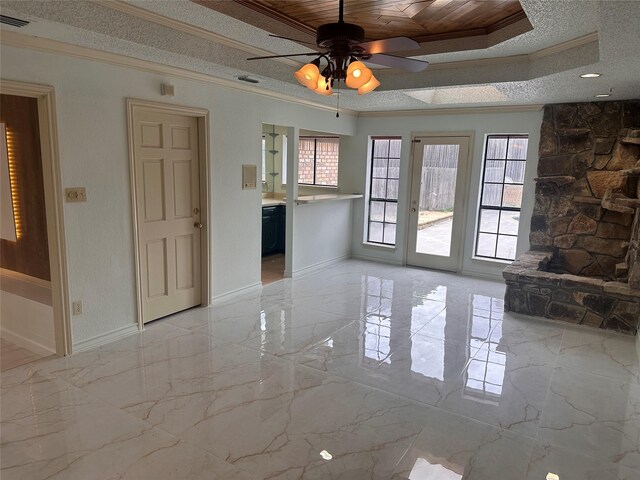 empty room featuring a tray ceiling, visible vents, ornamental molding, and ceiling fan