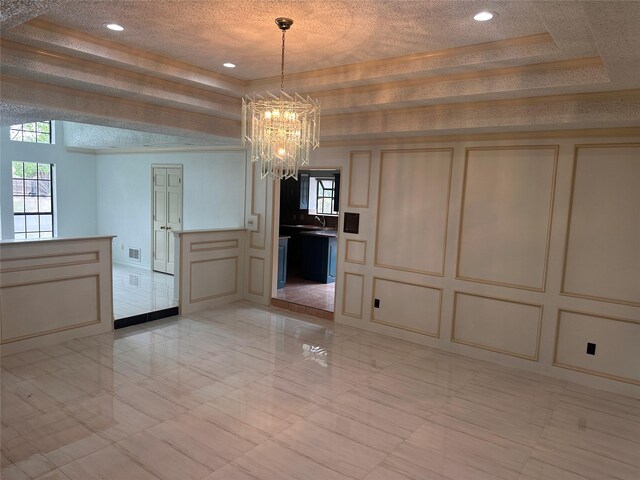 unfurnished dining area featuring marble finish floor, a chandelier, a decorative wall, and a wealth of natural light