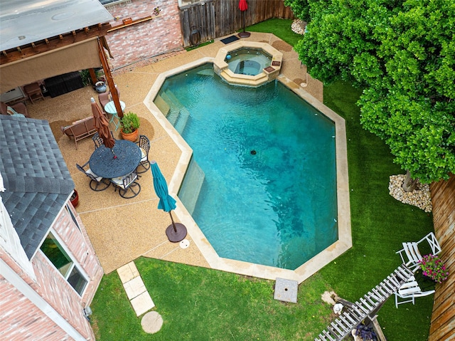 view of pool featuring a yard, a pool with connected hot tub, a fenced backyard, and a patio area