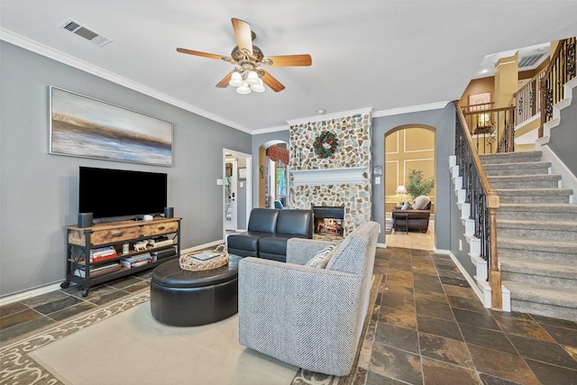 living area with visible vents, stone tile flooring, ornamental molding, stairway, and arched walkways
