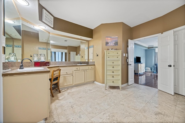 full bath with vanity and baseboards