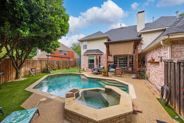 view of pool with a yard, a pool with connected hot tub, a fenced backyard, and a patio area