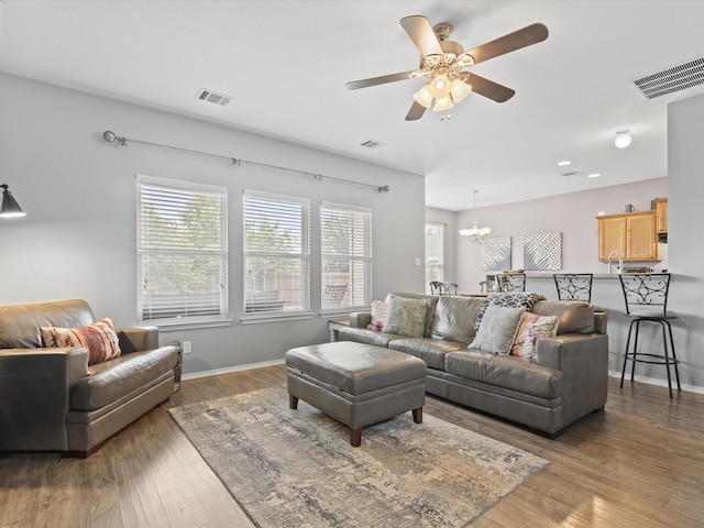 1646 Country Hls, Waxahachie, TX 75165 - living room featuring visible vents, baseboards, ceiling fan with notable chandelier, and wood finished floors