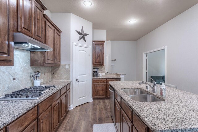 kitchen featuring a sink, dark wood finished floors, an island with sink, stainless steel appliances, and under cabinet range hood