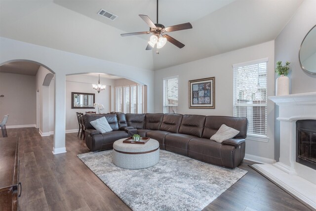 living area with arched walkways, visible vents, a healthy amount of sunlight, and ceiling fan with notable chandelier