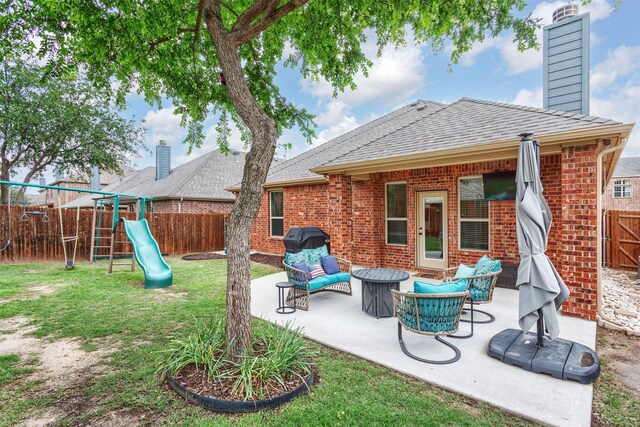 exterior space with a fenced backyard, brick siding, a playground, a patio area, and a yard