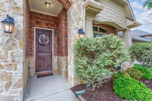 doorway to property with brick siding and stone siding