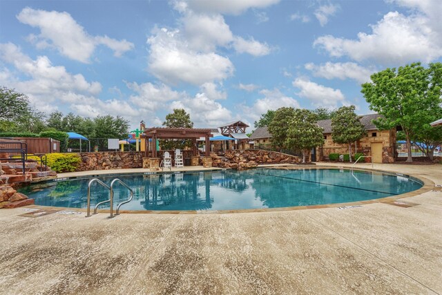 community pool featuring a patio and fence