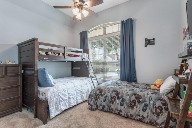 carpeted bedroom with a ceiling fan and lofted ceiling