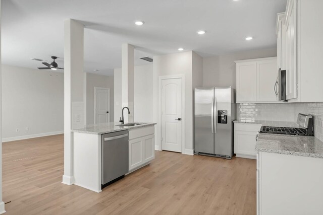 1105 Dye Blvd, Princeton, TX 75407 - kitchen with light stone counters, appliances with stainless steel finishes, a sink, light wood-style floors, and visible vents