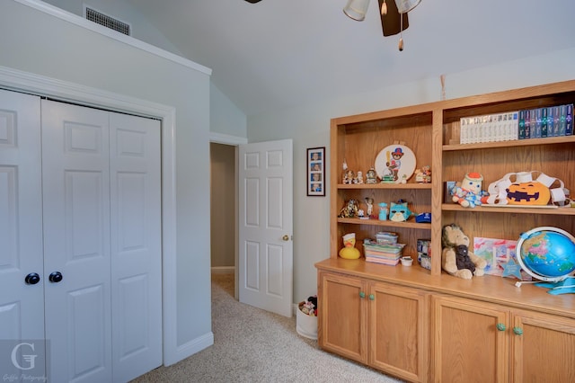 bedroom featuring ceiling fan, visible vents, vaulted ceiling, a closet, and light carpet