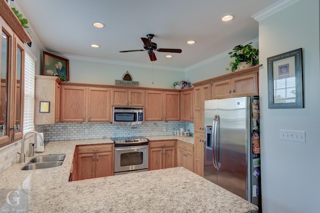 kitchen with a sink, appliances with stainless steel finishes, ceiling fan, and backsplash