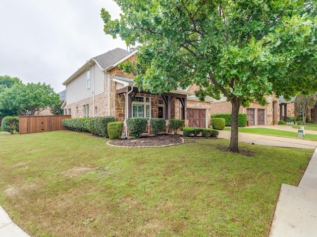 view of front of house featuring fence, a front lawn, stone siding, a garage, and concrete driveway