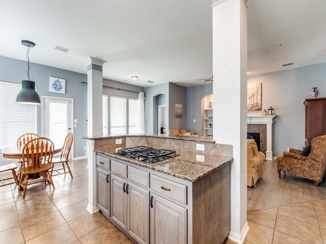 kitchen featuring visible vents, light stone countertops, open floor plan, light tile patterned floors, and black gas stovetop