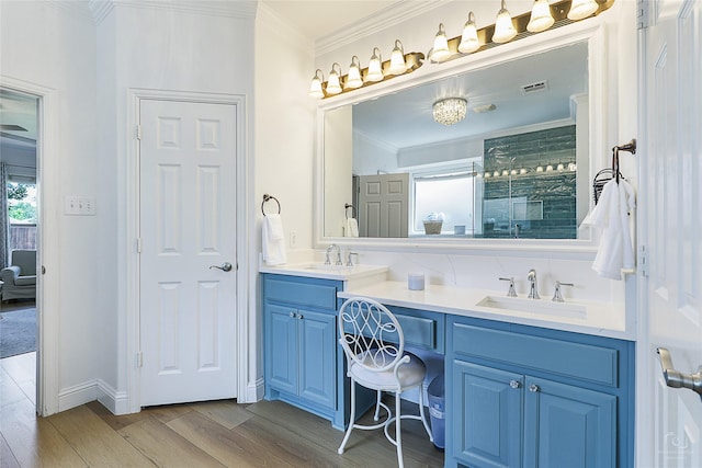 full bath with wood finished floors, crown molding, a stall shower, and double vanity