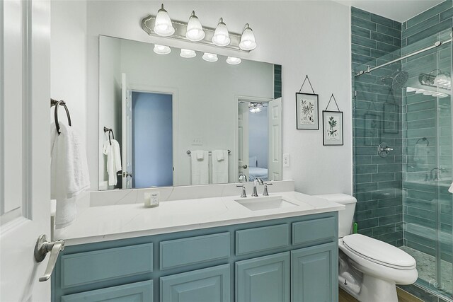 bathroom featuring a shower stall, toilet, vanity, and ensuite bath