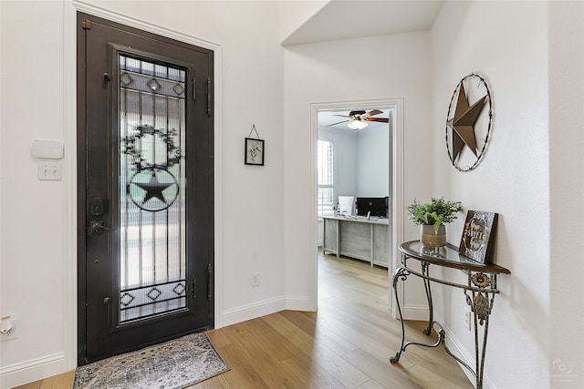 foyer featuring a ceiling fan, light wood-style flooring, and baseboards