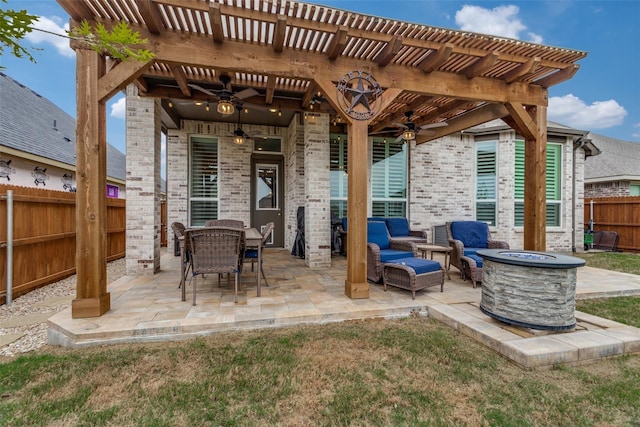 view of patio / terrace with a pergola, ceiling fan, a fenced backyard, and an outdoor fire pit