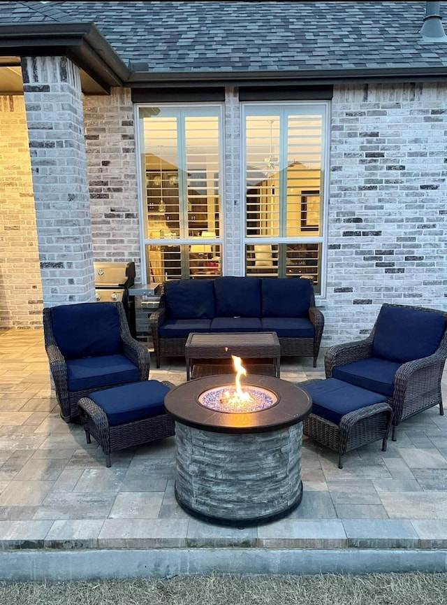 view of patio with an outdoor living space with a fire pit