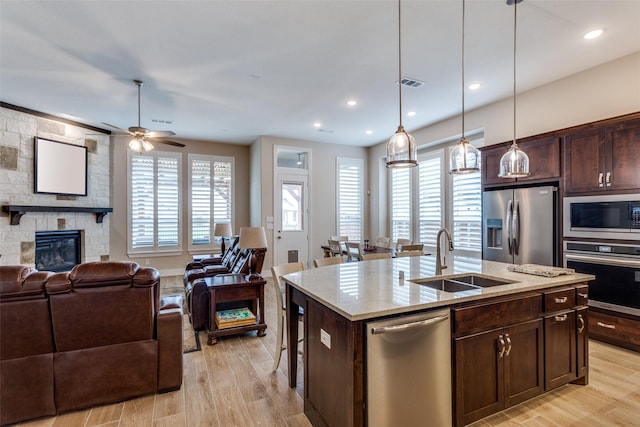 kitchen with a sink, visible vents, stainless steel appliances, and open floor plan