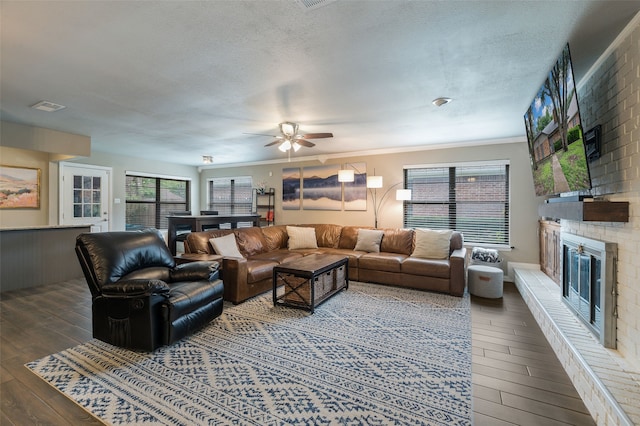 1600 Skyview Dr, Irving, TX 75060 - living room with wood-type flooring, a textured ceiling, ceiling fan, and a fireplace