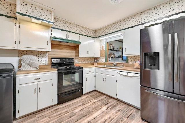 kitchen featuring stainless steel fridge, a sink, dishwasher, washer / dryer, and black range with electric stovetop