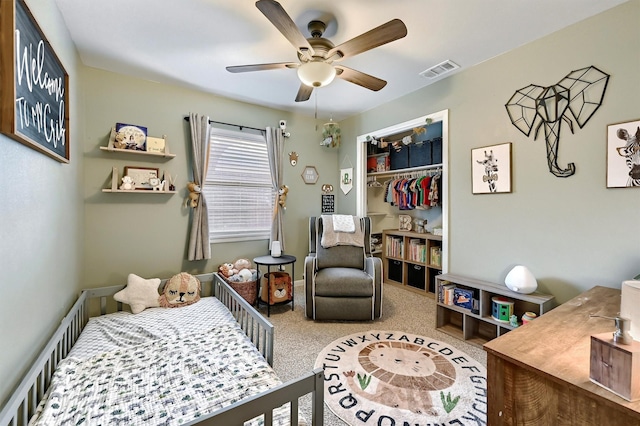 carpeted bedroom featuring a ceiling fan, visible vents, and a closet