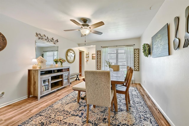 dining area with baseboards, ceiling fan, and light wood-style flooring