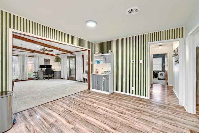 unfurnished living room featuring visible vents, ceiling fan, wood finished floors, and wallpapered walls