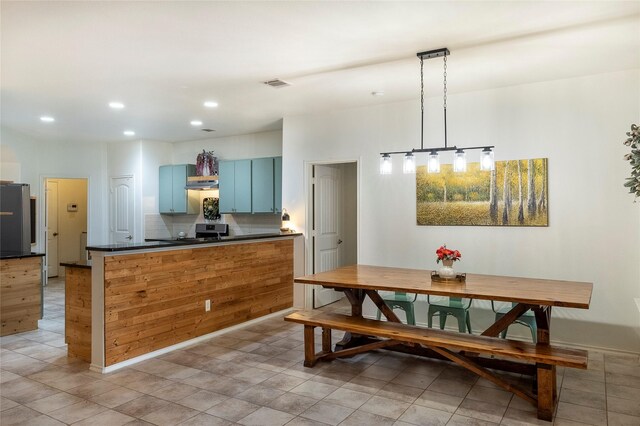 kitchen featuring blue cabinets, visible vents, dark countertops, stainless steel stove, and recessed lighting