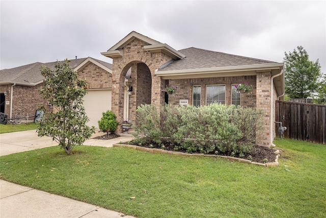 view of front of home featuring brick siding, a garage, and fence