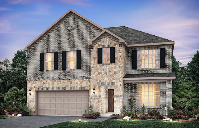 traditional-style house with brick siding, an attached garage, driveway, and stone siding