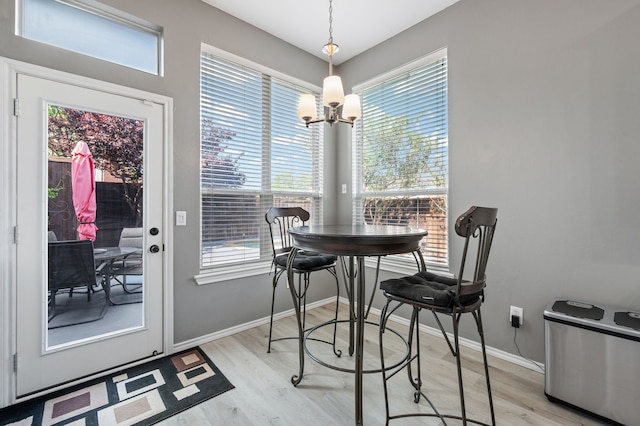 dining room with light wood-style floors, baseboards, a chandelier, and a wealth of natural light