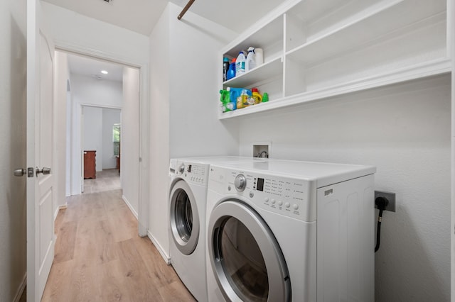 washroom featuring laundry area, light wood-style flooring, and washing machine and clothes dryer
