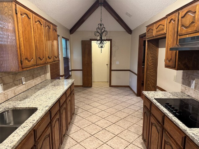 kitchen featuring black electric cooktop, backsplash, baseboards, under cabinet range hood, and pendant lighting