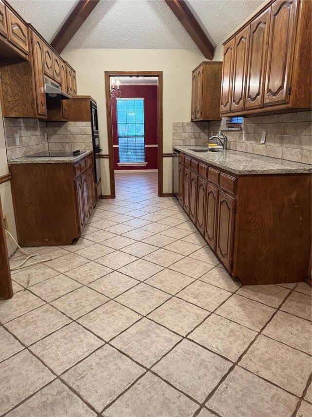 kitchen featuring beam ceiling, a textured ceiling, a sink, backsplash, and light tile patterned floors
