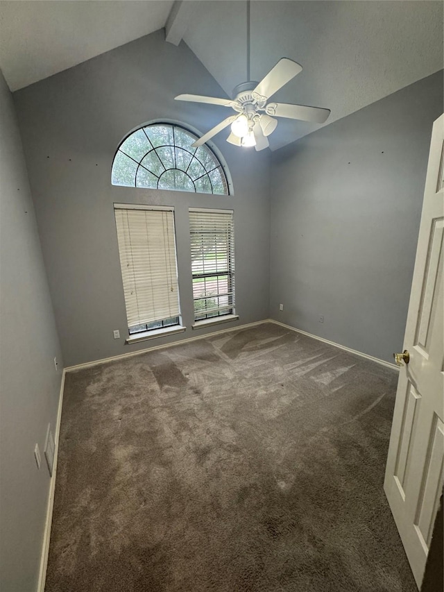 carpeted spare room featuring baseboards, vaulted ceiling with beams, and a ceiling fan