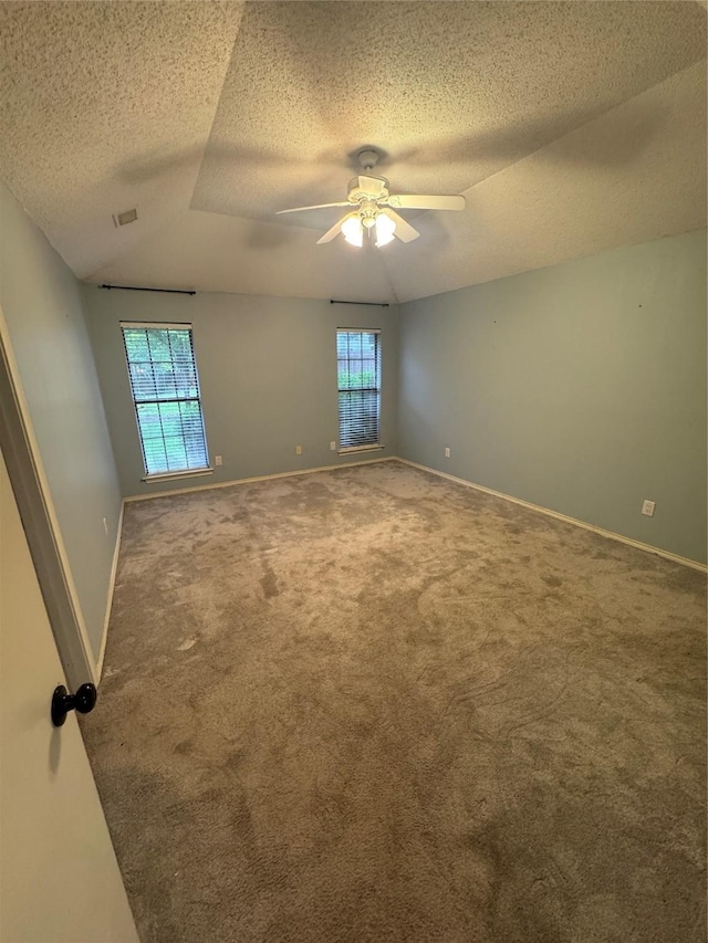 carpeted empty room featuring plenty of natural light, a textured ceiling, and ceiling fan