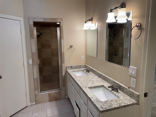 full bathroom with double vanity, a sink, tile patterned floors, and a shower stall
