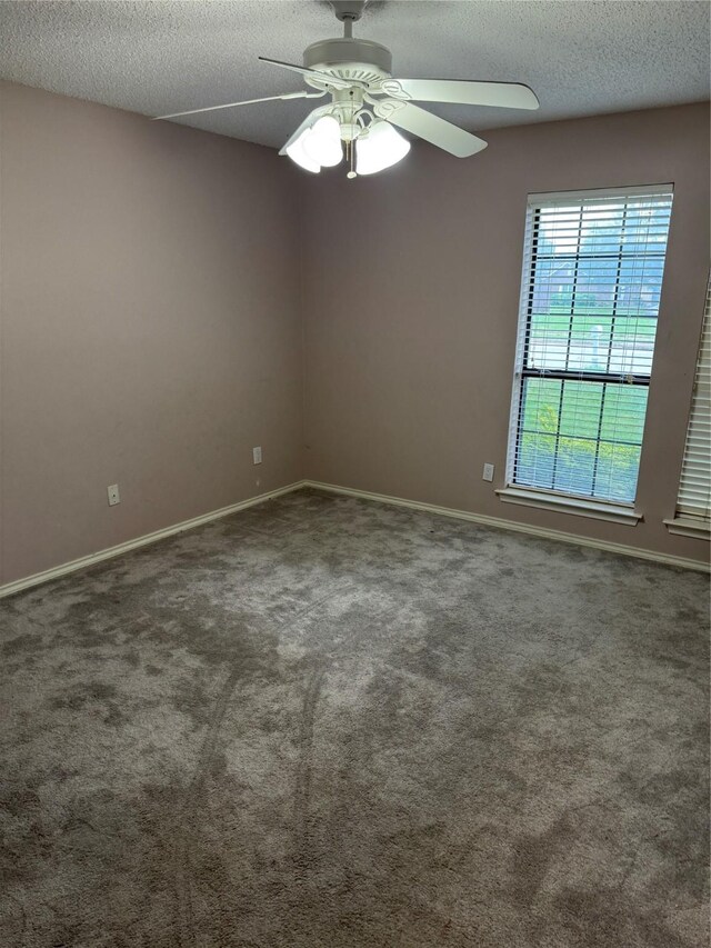 empty room with baseboards, a ceiling fan, a textured ceiling, and carpet flooring