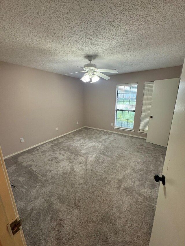 carpeted spare room with baseboards, a textured ceiling, and ceiling fan