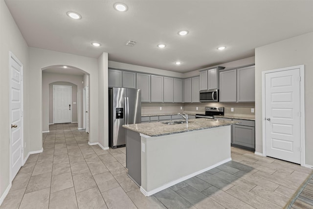 3819 Elkhorn Ln, Forney, TX 75126 - kitchen with appliances with stainless steel finishes, gray cabinetry, a sink, arched walkways, and recessed lighting