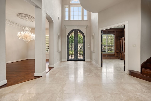 5404 Miramar Ln, Colleyville, TX 76034 - entrance foyer featuring arched walkways, a chandelier, french doors, baseboards, and a towering ceiling