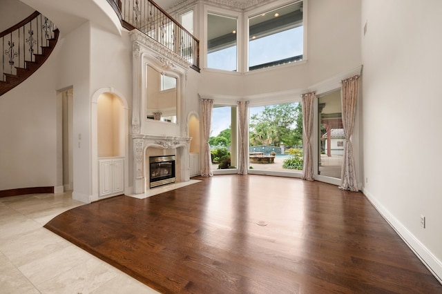 5404 Miramar Ln, Colleyville, TX 76034 - unfurnished living room with a high ceiling, a premium fireplace, stairway, baseboards, and wood finished floors