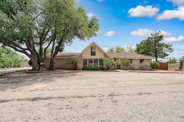 view of front of house featuring brick siding and fence