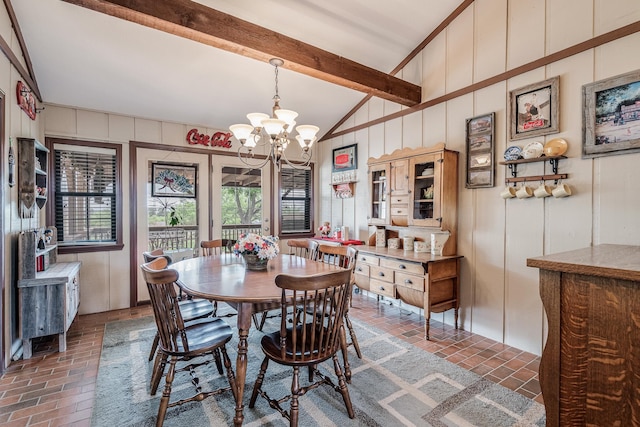 dining room featuring brick floor, lofted ceiling with beams, a decorative wall, and a notable chandelier