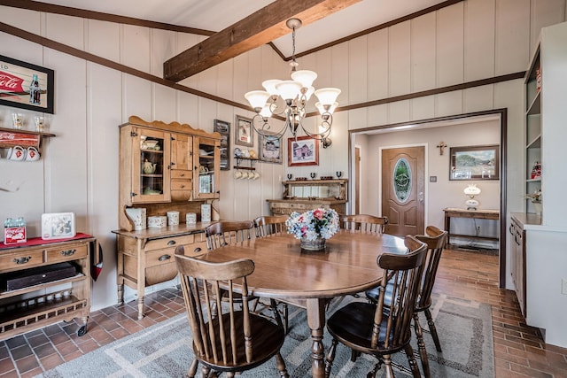dining area with an inviting chandelier, brick floor, and a decorative wall